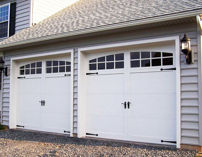 a garage with 2 side by side small white garage doors