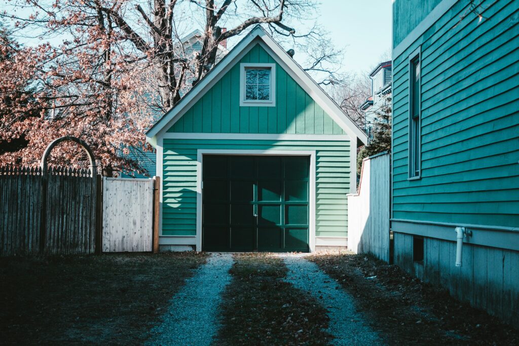 driveway with a green garage and a small green garage door