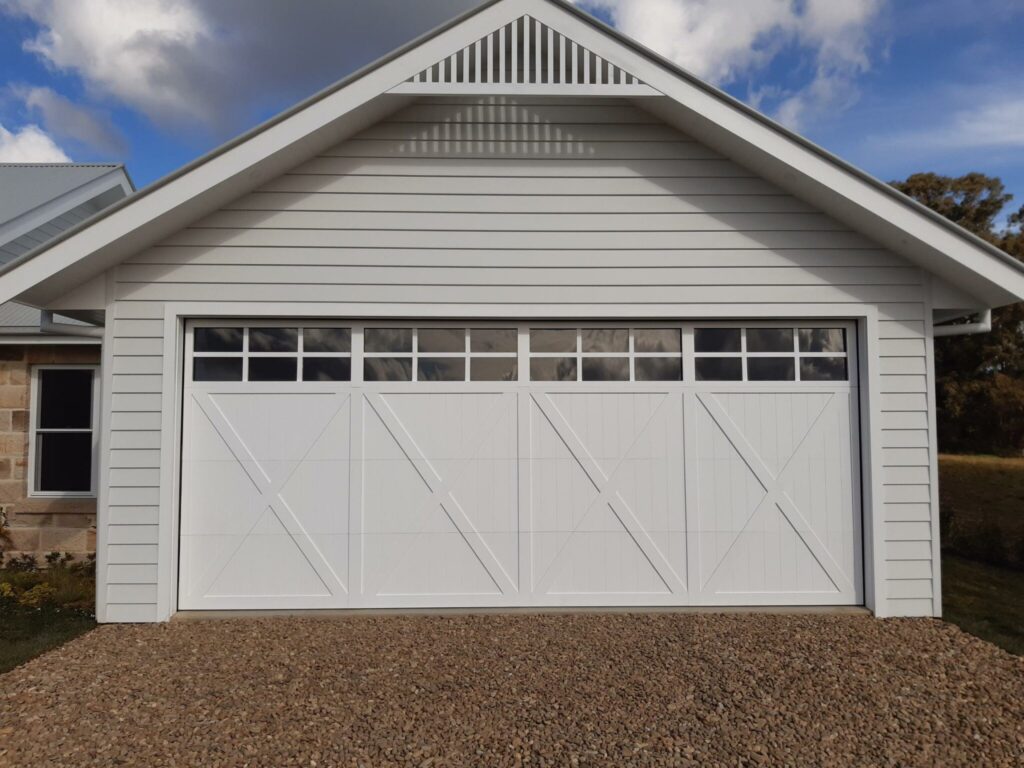 White garage with large white garage door with door windows